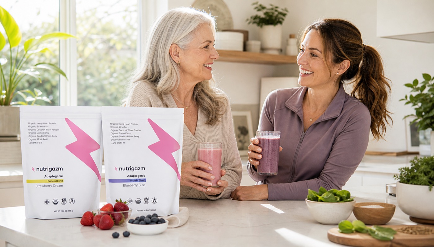 Two women smiling together with Nutrigazm shakes and product bags on the counter